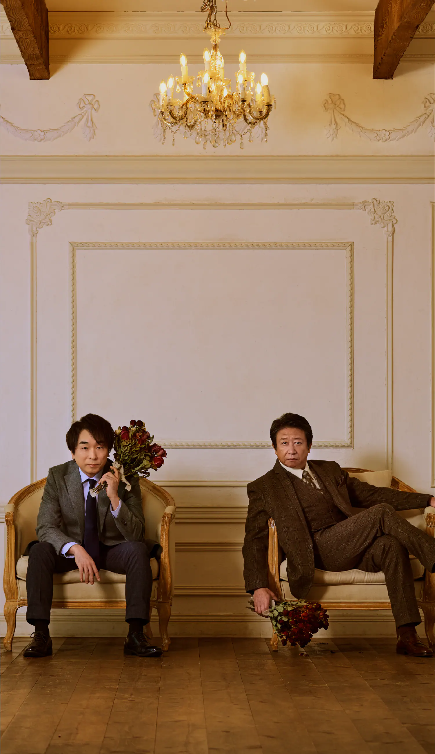 井上和彦と関智一が洋館の中で、ばらの花束を手にソファーに座っている写真